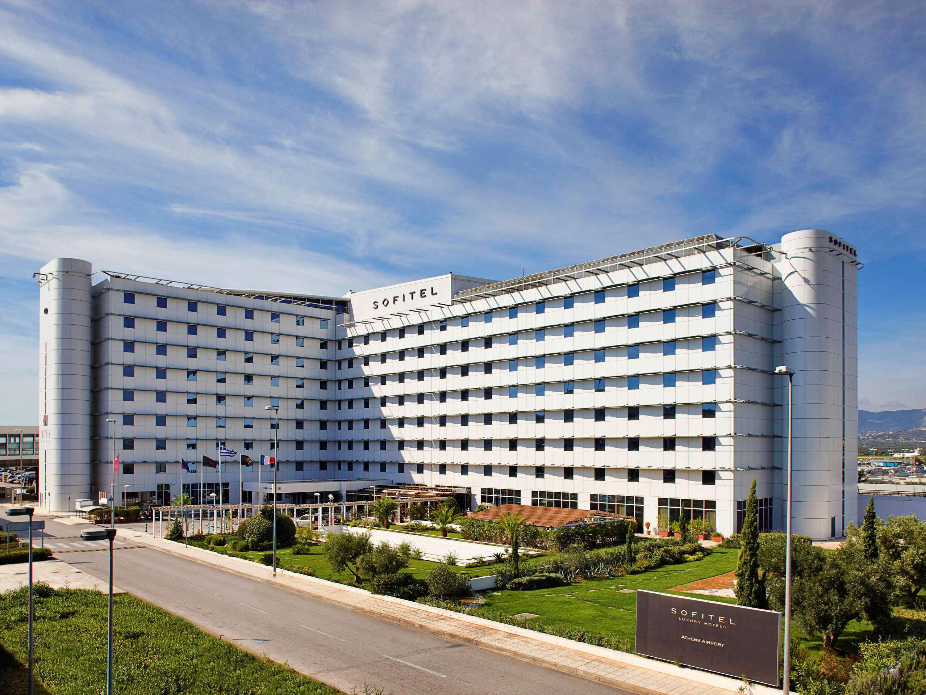 فندق سوفيتِل أثينا إيربورت Spáta المظهر الخارجي الصورة The photo shows a modern hotel building with a distinct architectural design. It is a multi-story structure featuring a combination of glass and concrete elements, characterized by a large facade that has a series of windows. The hotel appears to be 